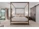 Bright main bedroom with a four-poster bed, barn door, and floor-to-ceiling windows at 302 Watteau Ct, Henderson, NV 89012
