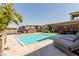 Resort-style backyard with a modern pool, lounge chairs, and covered patio for outdoor entertainment at 302 Watteau Ct, Henderson, NV 89012