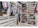 Organized walk-in closet with shelves displaying a large collection of shoes, clothes, and accessories in a well-lit space at 302 Watteau Ct, Henderson, NV 89012