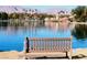 Scenic lake view featuring a tranquil body of water with building, palm trees, and a bench in the foreground at 3151 Soaring Gulls Dr # 2035, Las Vegas, NV 89128