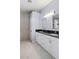 Bathroom with dual sinks, white cabinets, black countertops, and walk-in shower at 3197 Castle Canyon Ave, Henderson, NV 89052