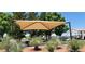 Playground area with sunshade, mature trees, and seating at 3318 N Decatur Blvd # 1002, Las Vegas, NV 89130