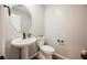 A powder bathroom features a pedestal sink, round mirror, and modern black fixtures at 3525 Serravalle Ln, Henderson, NV 89044
