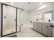 Modern bathroom featuring a glass-enclosed shower, soaking tub, double vanity, and sleek black fixtures for a spa-like experience at 3525 Serravalle Ln, Henderson, NV 89044