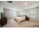 Bright bedroom featuring neutral walls, carpet flooring, and a comfortable queen-sized bed with coordinated nightstands at 3525 Serravalle Ln, Henderson, NV 89044