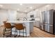 This well-designed kitchen island features chairs, a sink, and a stainless steel refrigerator at 3525 Serravalle Ln, Henderson, NV 89044