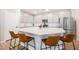 The spacious kitchen island features seating for four, a sink, and a white quartz countertop at 3525 Serravalle Ln, Henderson, NV 89044