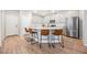 Bright kitchen showcases an island with chairs, stainless steel refrigerator and light gray cabinets at 3525 Serravalle Ln, Henderson, NV 89044