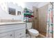 Well-lit bathroom featuring a vanity, decorative shelf and tiled shower with glass door and showerhead at 3814 Connie Ave, Las Vegas, NV 89115