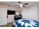 Bedroom features hardwood floors, ceiling fan, large TV, and stylish dresser with mirror at 3814 Connie Ave, Las Vegas, NV 89115