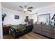 A bedroom with a ceiling fan, a dresser with a mirror, and a bed with a black and green blanket at 3814 Connie Ave, Las Vegas, NV 89115