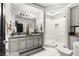 Modern bathroom features double sinks, granite countertops, a large mirror, and a walk-in shower with white marble tiling at 439 Cannes St, Henderson, NV 89015