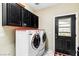 Laundry room with modern washer and dryer, black cabinets, red countertop, and convenient outdoor access at 439 Cannes St, Henderson, NV 89015