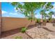Backyard patio area with desert landscaping, stone pavers, and a young leafy tree at 45 Via Di Mello, Henderson, NV 89011