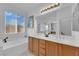 Bathroom featuring double vanity, soaking tub, and large window with bright, natural light at 45 Via Di Mello, Henderson, NV 89011