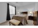 Bedroom featuring a bed, two side tables with lamps, a bench and dark wooden furniture at 45 Via Di Mello, Henderson, NV 89011