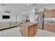 Spacious kitchen open to the living room boasts an island and stainless steel refrigerator at 45 Via Di Mello, Henderson, NV 89011