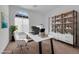 Bright home office with modern desk, shelving, and natural light from a large window at 45 Via Di Mello, Henderson, NV 89011