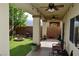 Covered back patio with ceiling fans and lighting overlooks a private green back yard at 4770 Lorenzo Way, Pahrump, NV 89061