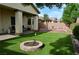 Private backyard with artificial turf, brick fire pit, mature landscaping and a covered patio at 4770 Lorenzo Way, Pahrump, NV 89061