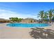 A large community pool is surrounded by palm trees, lounge chairs and clear blue skies at 4770 Lorenzo Way, Pahrump, NV 89061