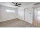 Bedroom with white block walls, a ceiling fan, new carpet, and access to hallway and closet at 4957 E Harmon Ave, Las Vegas, NV 89121