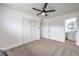 Bedroom with ceiling fan, new carpet, closet, and access to bathroom at 4957 E Harmon Ave, Las Vegas, NV 89121
