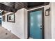 Close-up of the home's entrance featuring a modern turquoise door and dark trim at 4957 E Harmon Ave, Las Vegas, NV 89121