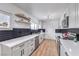 Updated kitchen featuring white cabinets, black backsplash, stainless steel appliances, quartz counters, and wood-look floors at 4957 E Harmon Ave, Las Vegas, NV 89121