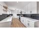 Modern kitchen features white cabinets, stainless steel appliances, and dark backsplash at 4957 E Harmon Ave, Las Vegas, NV 89121