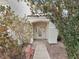 Inviting front entrance featuring a decorative glass door, mature landscaping, and a charming archway at 504 Landra Ln, Henderson, NV 89015