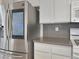 Modern kitchen with a stainless steel refrigerator, gray counter tops, and white cabinets at 504 Landra Ln, Henderson, NV 89015