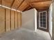 Bare shed interior with plywood walls, concrete floor, and door leading to the outside at 504 Landra Ln, Henderson, NV 89015