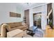 Comfortable living room with brown sofa, balcony access, and a sleek entertainment setup at 5751 E Hacienda Ave # 119, Las Vegas, NV 89122