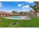 Community pool surrounded by green grass and shady trees, a refreshing oasis for residents at 5751 E Hacienda Ave # 119, Las Vegas, NV 89122