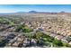 A wide shot shows the community with mountain views, lush green landscaping, and well-maintained homes at 580 Via Di Parione Ct, Henderson, NV 89011