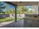 A covered patio with an outdoor kitchen overlooks the manicured backyard and stone bench area, great for relaxing at 580 Via Di Parione Ct, Henderson, NV 89011