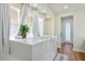 A serene bathroom features a soaking tub with curtains for privacy and a bright, tiled interior for a relaxing experience at 580 Via Di Parione Ct, Henderson, NV 89011