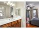 This bright bathroom features a wood vanity, a mirrored wall, and an adjoining bedroom for ultimate convenience at 580 Via Di Parione Ct, Henderson, NV 89011