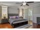 This cozy bedroom features a ceiling fan, wood floors, natural light, and an adjacent bathroom with a glass door at 580 Via Di Parione Ct, Henderson, NV 89011