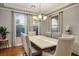 Dining room with hardwood floors, stone-top table, seating for six, and natural light from large windows at 580 Via Di Parione Ct, Henderson, NV 89011