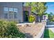 Landscaped front yard features decorative stone, lush greenery, a stone pillar, and an arched entryway at 580 Via Di Parione Ct, Henderson, NV 89011