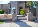 Home's entrance features stone steps, urn planters, yellow flowering shrubbery, and a manicured lawn at 580 Via Di Parione Ct, Henderson, NV 89011