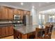 Traditional-style kitchen features stainless appliances, wood cabinets, island with bar stool seating, and granite countertops at 580 Via Di Parione Ct, Henderson, NV 89011