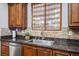 Kitchen with wood cabinets, granite countertops, stainless steel appliances, and stone backsplash at 580 Via Di Parione Ct, Henderson, NV 89011