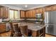Traditional-style kitchen features stainless appliances, wood cabinets, island with bar stool seating, and granite countertops at 580 Via Di Parione Ct, Henderson, NV 89011