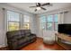 Sitting room features wood floors, large windows with blinds, and comfortable seating at 580 Via Di Parione Ct, Henderson, NV 89011