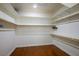 This spacious walk-in closet features wood floors and ample shelving and hanging storage for clothes and accessories at 580 Via Di Parione Ct, Henderson, NV 89011