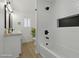 Stylish bathroom with white textured tiles, black fixtures, and a shower over tub at 613 Kings Pl, Boulder City, NV 89005