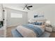 Inviting bedroom with a ceiling fan, plush carpet, and a comfortable bed with blue accents at 613 Kings Pl, Boulder City, NV 89005